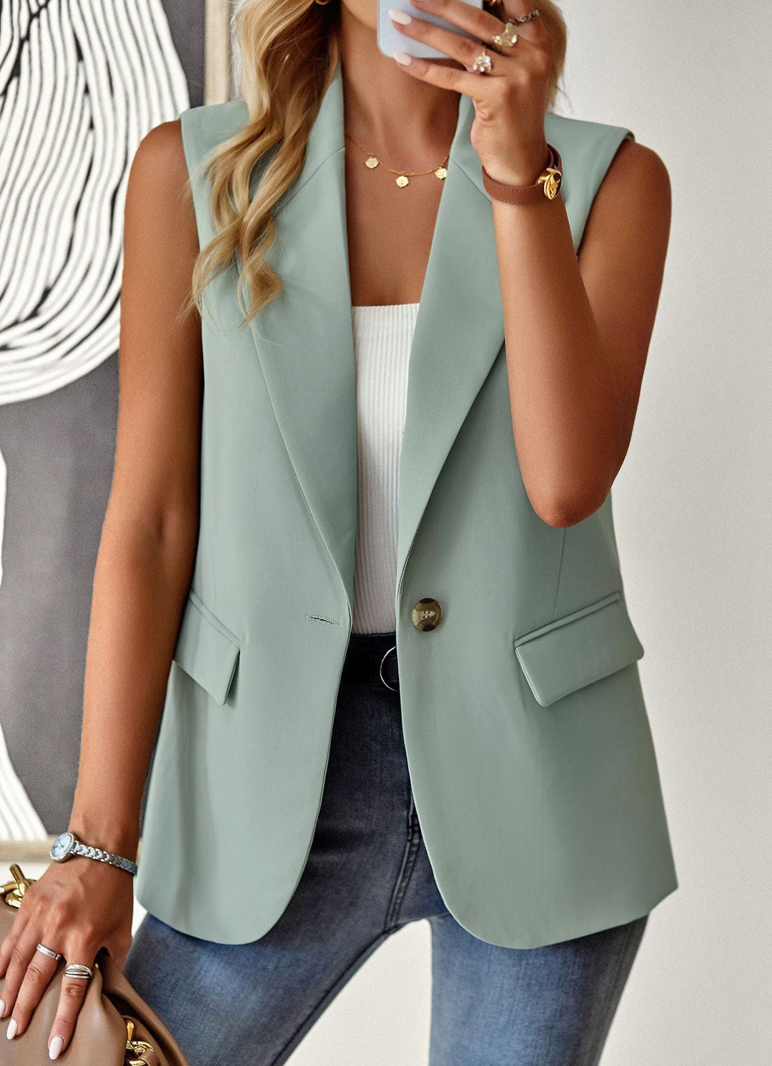 Dam i svart ärmlös blazer-topp på kontoret. Elegant och figurnära stil för en professionell look.