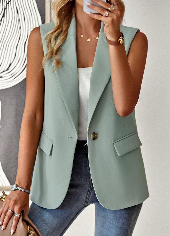 Dam i svart ärmlös blazer-topp på kontoret. Elegant och figurnära stil för en professionell look.