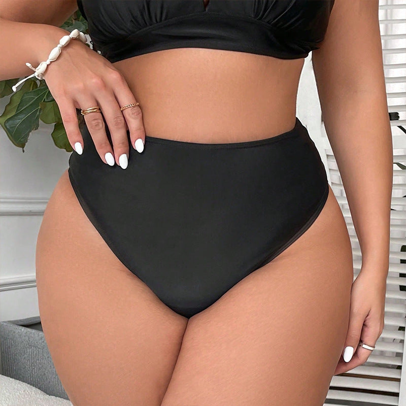 Moderiktig svart baddräktsunderdel med hög midja och asymmetriska cut-outs, elegant strandmode för kvinnor.