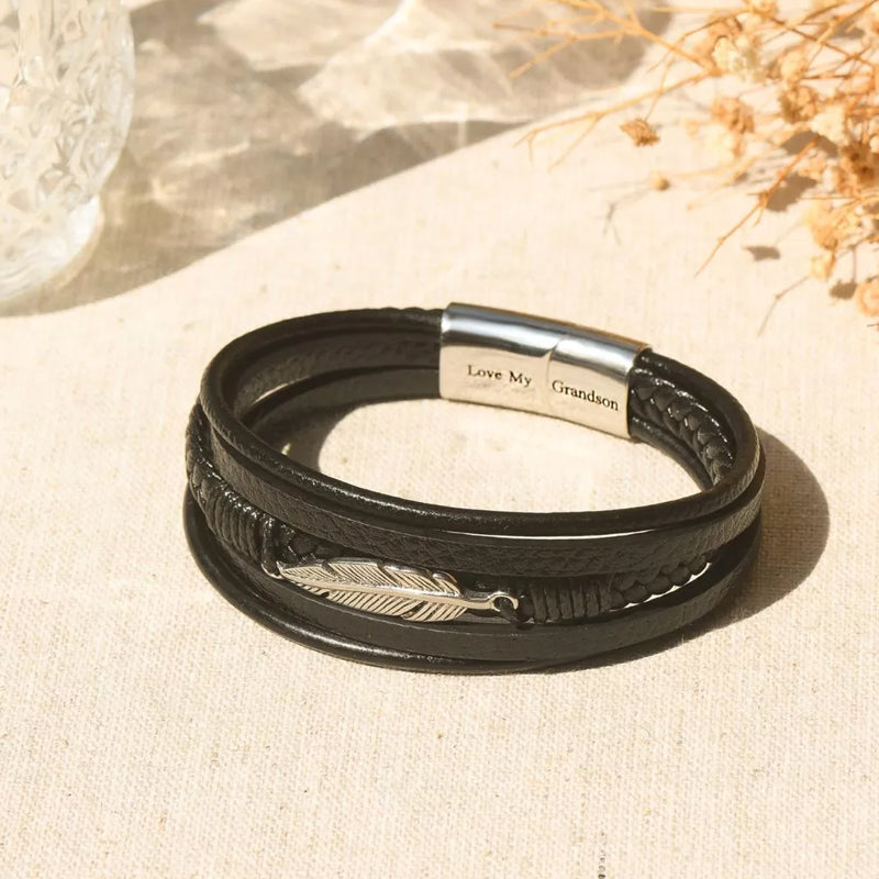 Svart herrarmband med fjäderdesign, justerbart och stilrent för en elegant look, symboliserar frihet.