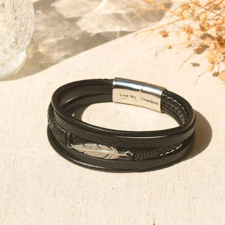 Svart herrarmband med fjäderdesign, justerbart och stilrent för en elegant look, symboliserar frihet.