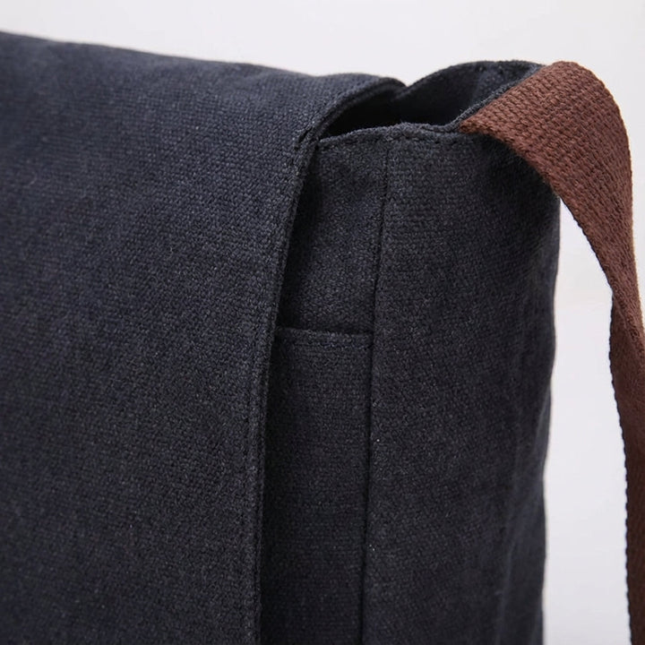 Svart unisex canvas crossbodyväska, slitstark och mångsidig, perfekt för pendling eller dagligt bruk.