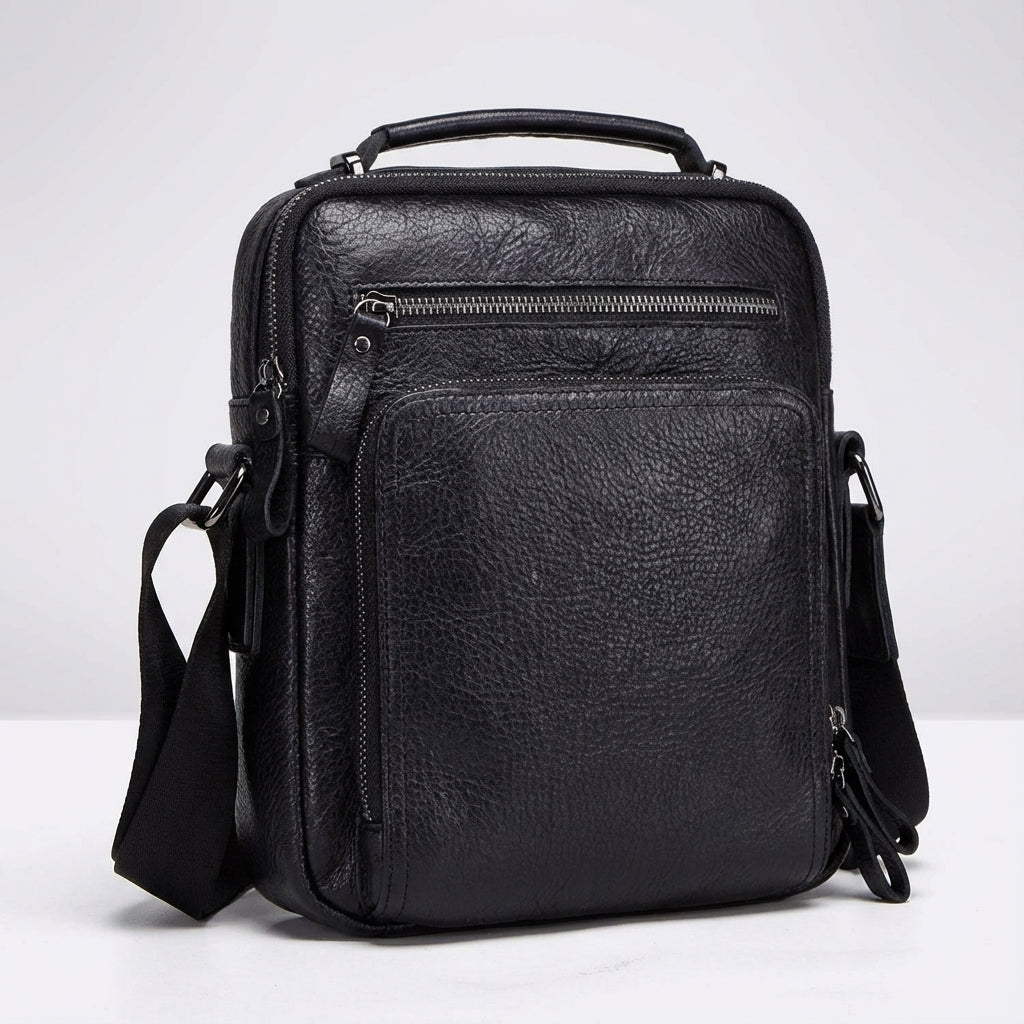Organiserad läder messengerbag, svart och kompakt. En mångsidig unisex arbets- och studieväska med axelrem.