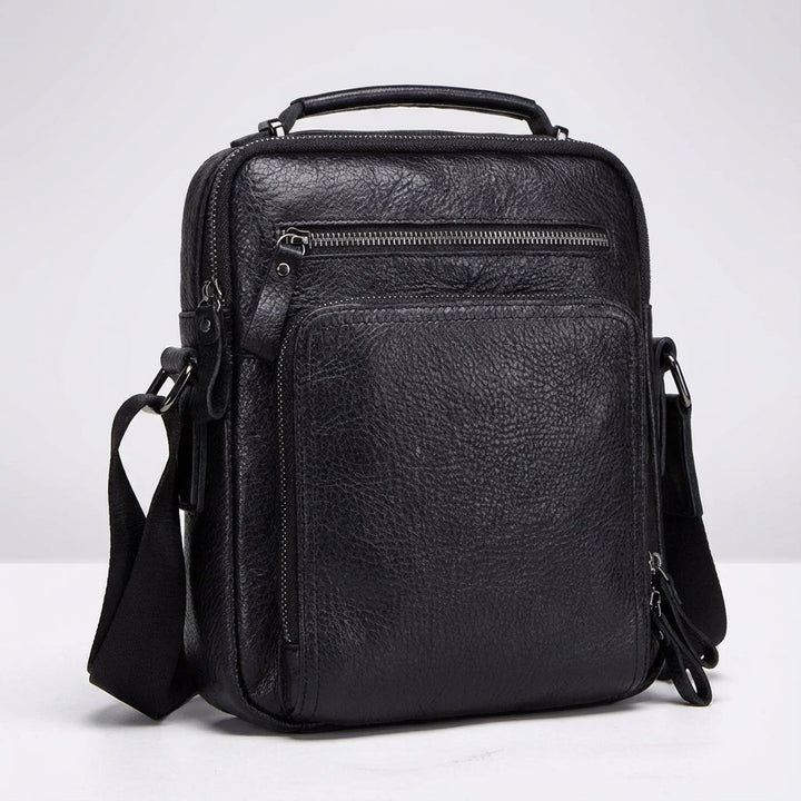 Organiserad läder messengerbag, svart och kompakt. En mångsidig unisex arbets- och studieväska med axelrem.