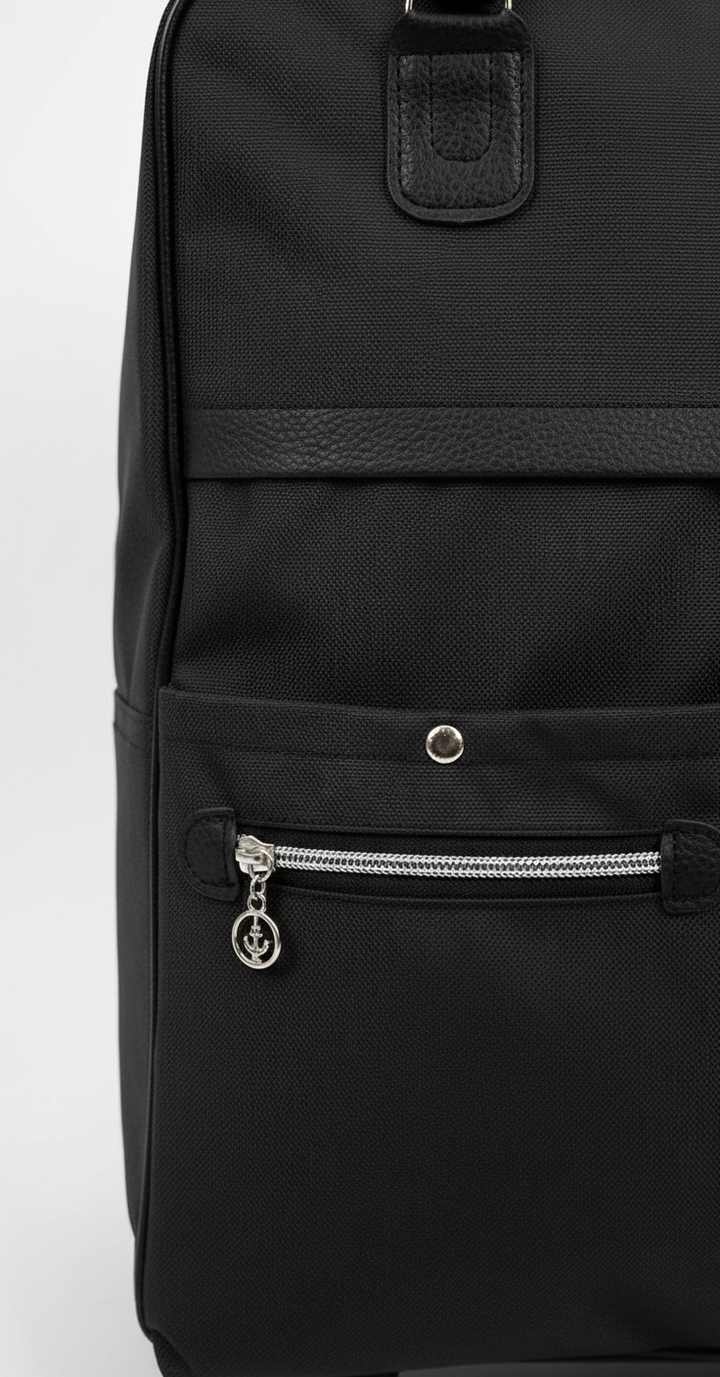 Robust men lätt resväska i slitstarkt svart oxfordtyg, optimalt handbagage för frekventa flygresor.