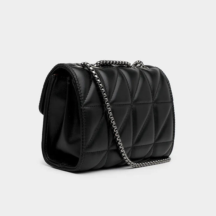 Kvinna bär elegant svart messengerväska, perfekt för en chic och avslappnad modekänsla i staden.