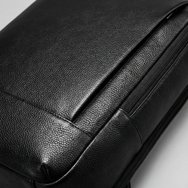 Hållbar svart unisex ryggsäck i läder för skol- och arbetsbruk, med smart organisering och laptopfack (17 tum).