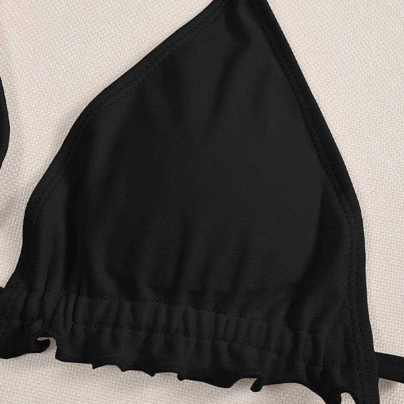 Damtriangelbikini i svart med chic volangdetalj och justerbara axelband för perfekt passform. Ett måste för strandmode.