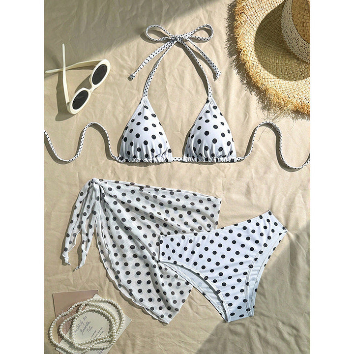 Svart triangelbikini med vita prickar och matchande cover-up för dam. Elegant strandkläder för sommar.