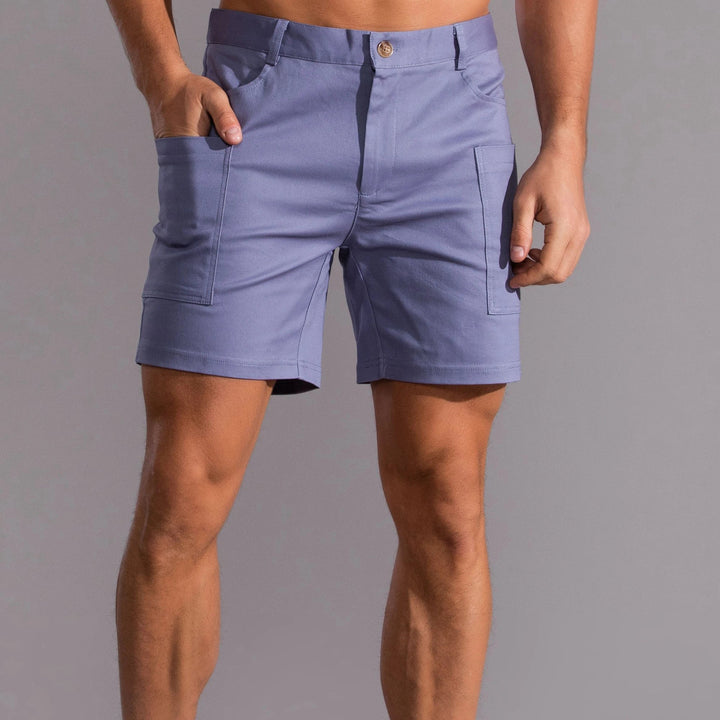 Man i blå utility-shorts med praktiska fickor framtill