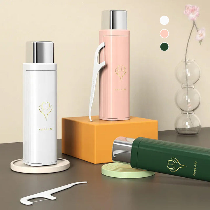 "Tandtrådsdispenser för resor i grön, rosa, vit. Bärbar och kompakt accessoar för enkel användning och påfyllning."