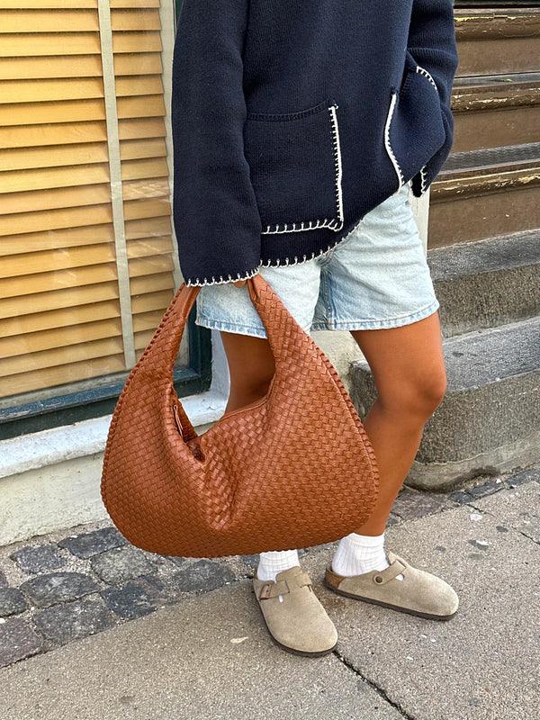 Detaljbild på axelväska med elegant vävd design och hantverk
