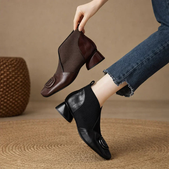 Två par ankelboots i svart och brun färg som hålls upp