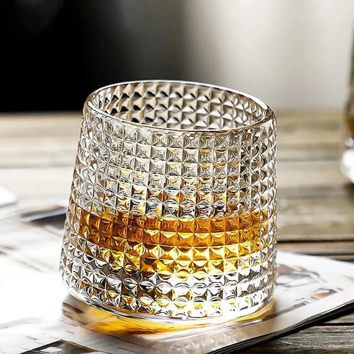 Carvallo texturerat roterande whiskyglas med square effekt fyllt med whisky på ett bord