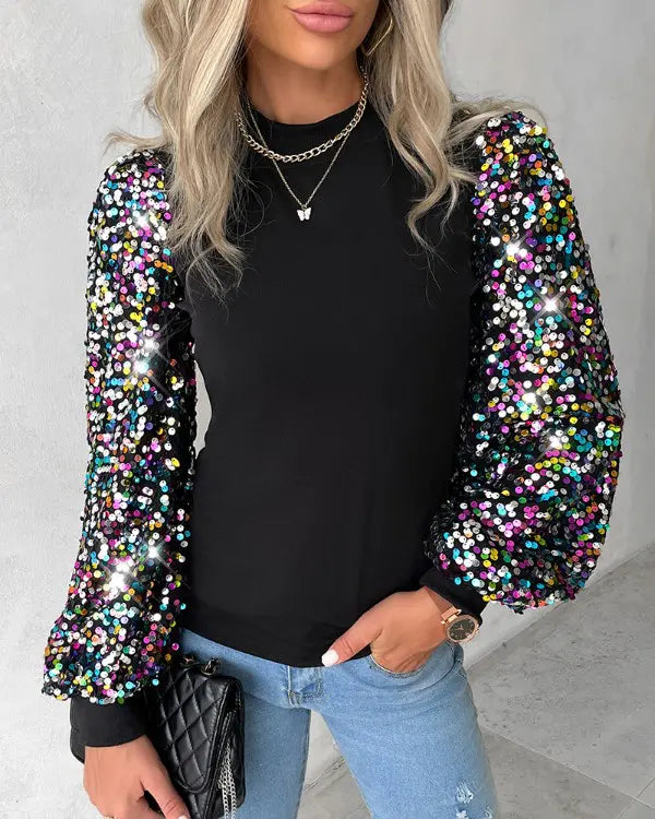 Snygg damtopp med svarta paneler och glittrande ärmar