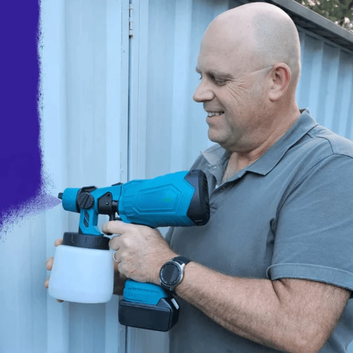Färgsprutpistol applicerar färg jämnt på trästaket, visar effektiviteten vid utomhusmålning.