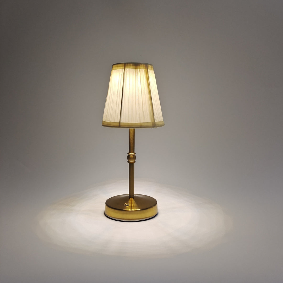 Trådlös LED-bordslampa i elegant guldfärg med touchfunktion tänd på ett bord