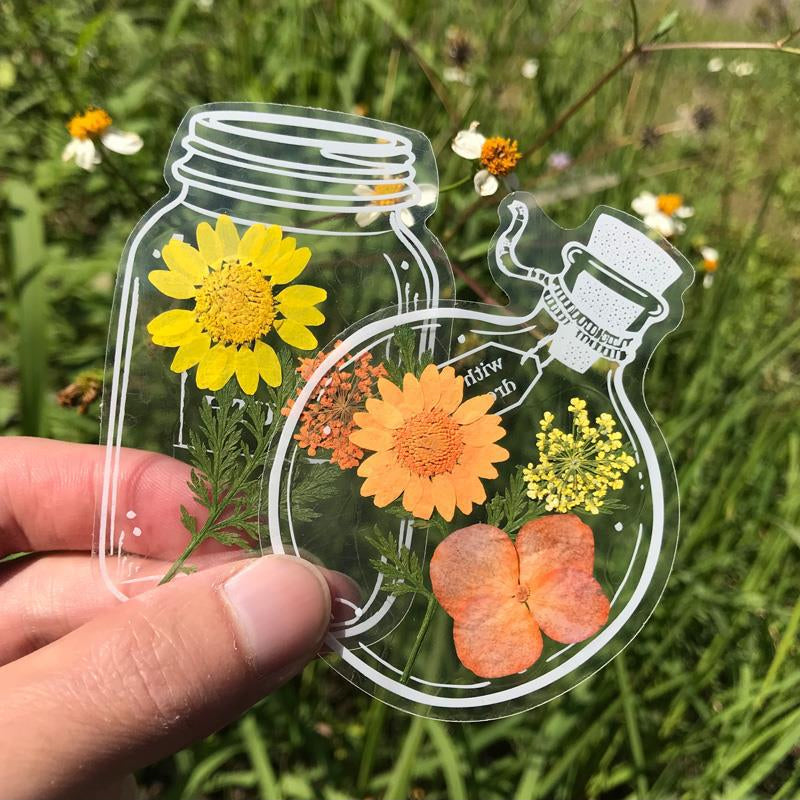 "Transparent bokmärke med torkade blommor, handgjord, elegant design, tunt och hållbart; perfekt för bokälskare."