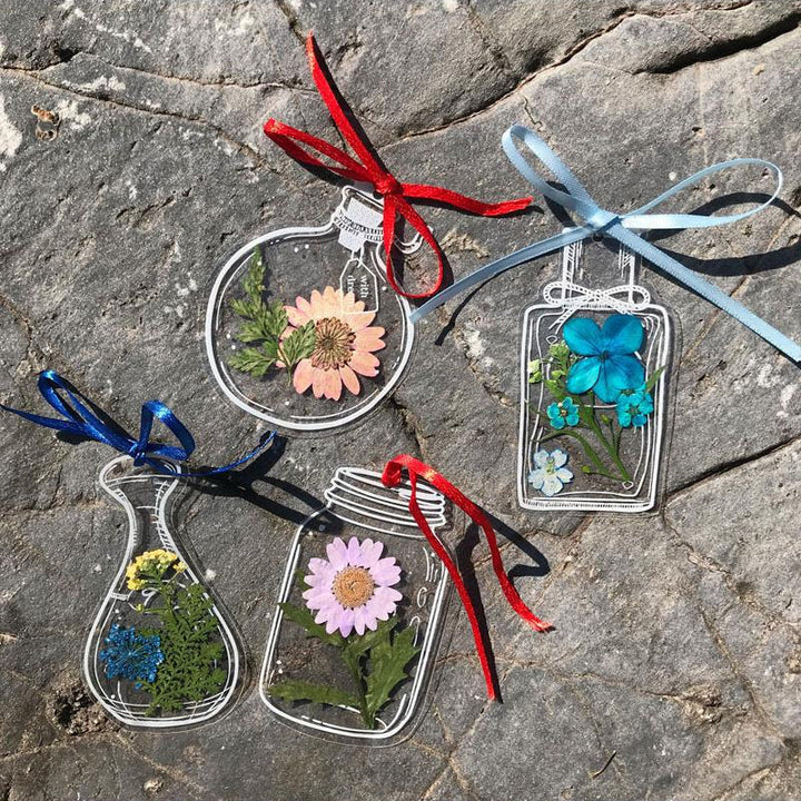 "Transparent bokmärke med torkade blommor, handgjord, elegant design, tunt och hållbart; perfekt för bokälskare."