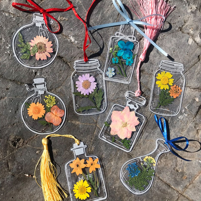 "Transparent bokmärke med torkade blommor, handgjord, elegant design, tunt och hållbart; perfekt för bokälskare."