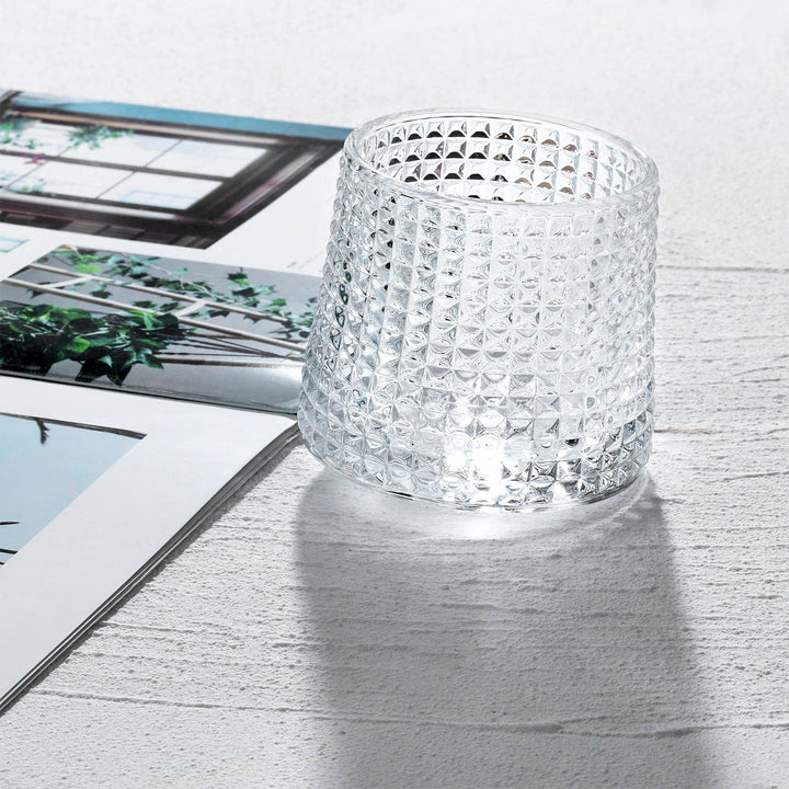 Närbild på ett glänsande klart whiskyglas, tumbler, med modern design, redo för din favoritdryck.