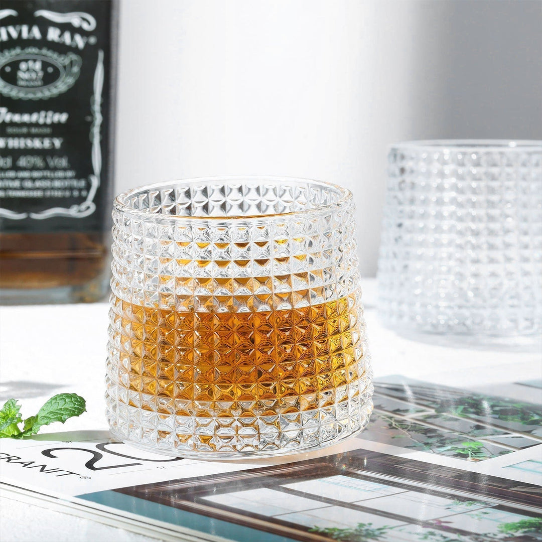 Detaljbild av ett robust whiskyglas, tumbler, som visar dess tunga botten och klara glaskvalitet.