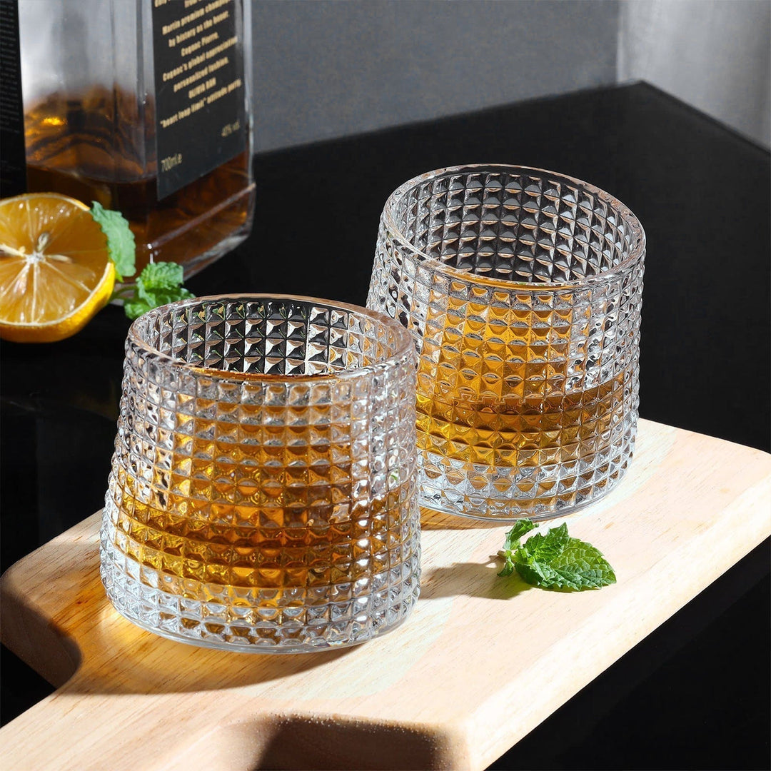 Ensam elegant tumbler whiskyglas, fyllt med is och en gyllene dryck, för avkopplande stunder.