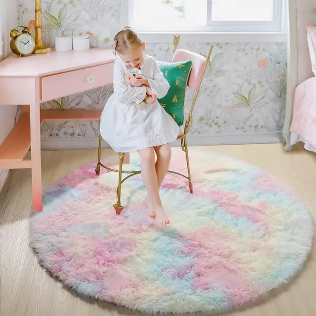 Ett barn som sitter på en färgglad regnbågsfärgad rund plyschmatta i ett rosa rum