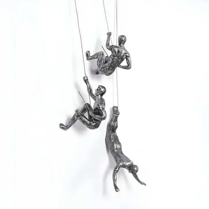 Dynamisk väggskulptur: Set med klättrande man-figurer i silver harts.