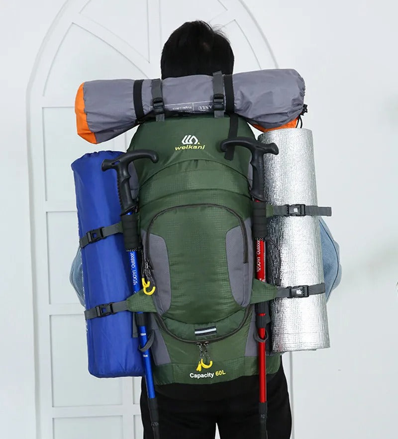 Vandrare bär en 60L unisex vattentät ryggsäck, redo för trekking och friluftsliv i skogen.