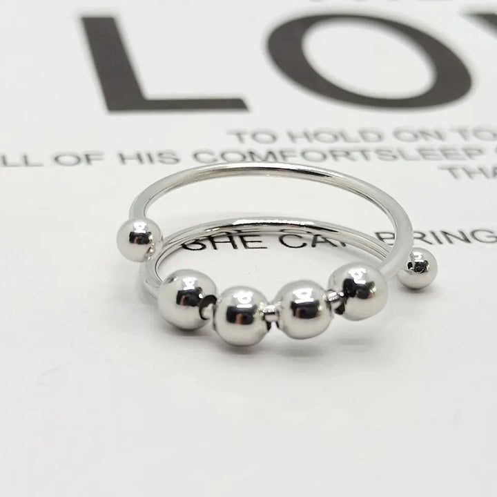 Unisex avstressande ring Serena i silver, justerbar för ångestlindring och fokus. Elegant modeaccessoar.