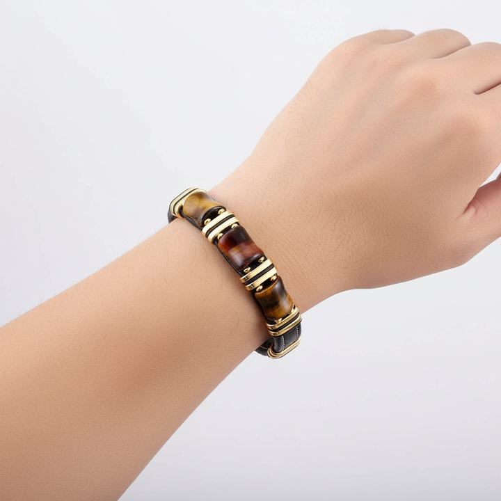 Närbild på unisex berlockarmband med skimrande tigeröga-pärlor och flätat läder. Accessoar för styrka.