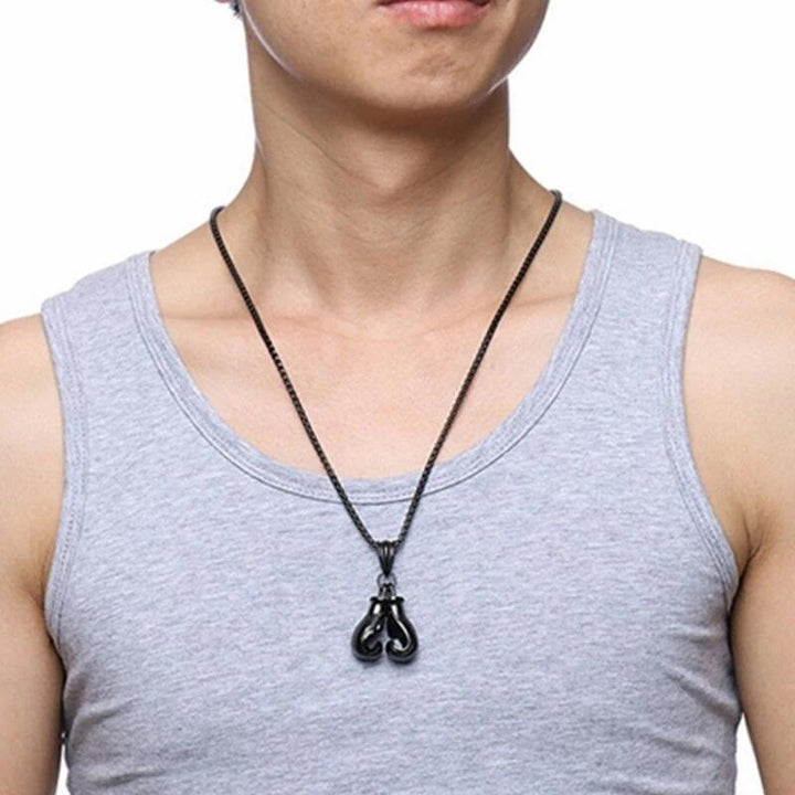 "Unisex boxhandskar halsband i ett glänsande guldigt titanstål, symboliserar styrka och stil för boxningsentusiaster."