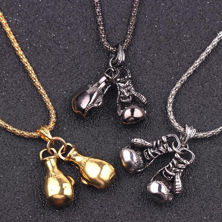 "Unisex boxhandskar halsband i ett glänsande guldigt titanstål, symboliserar styrka och stil för boxningsentusiaster."