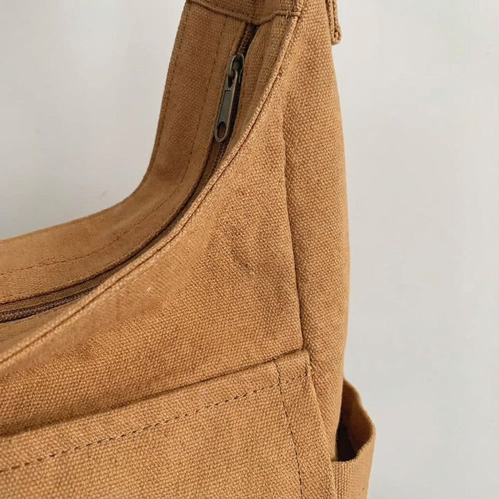 Slitstark unisex axelväska i canvas, crossbody-design med smarta fack, idealisk som dagsväska.