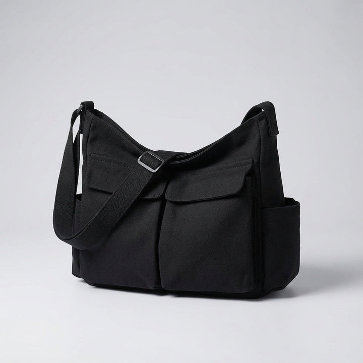 Grön canvas messengerbag, unisex modell med justerbar axelrem och rymliga fack för organiserad förvaring.