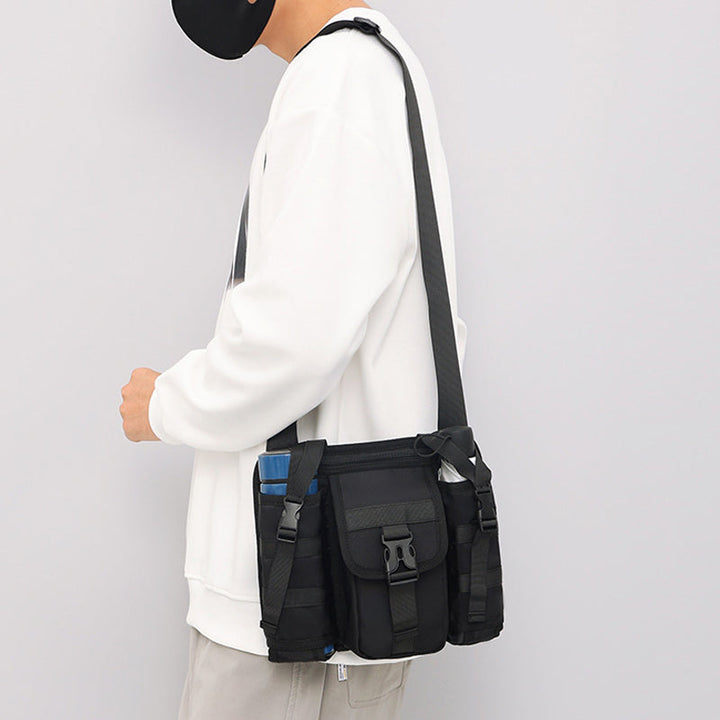 Unisex crossbody axelväska i tåligt tyg, grå. Framifrån med dragkedjor och justerbar rem, perfekt för organiserad förvaring.