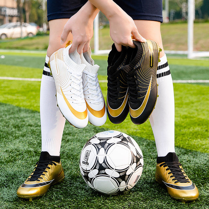 Sidosikt av de professionella unisex fotbollsskorna i guld färg med fokus på sulan.
