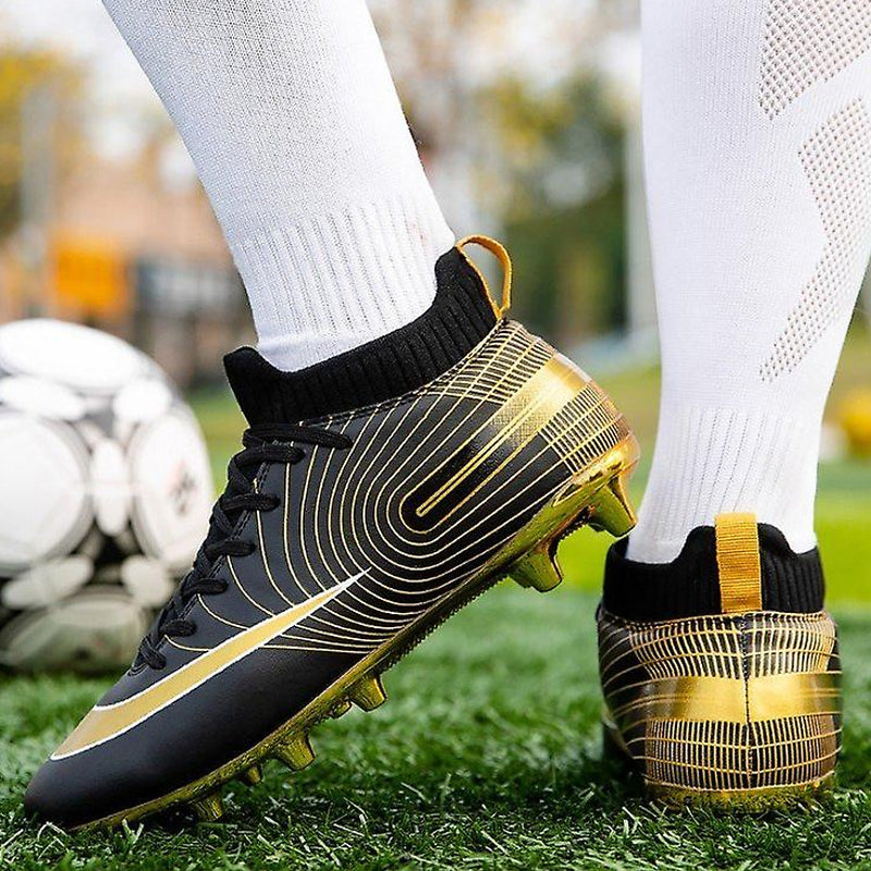 Närbild på de professionella unisex fotbollsskorna i svart färg med guldpläterad sula.