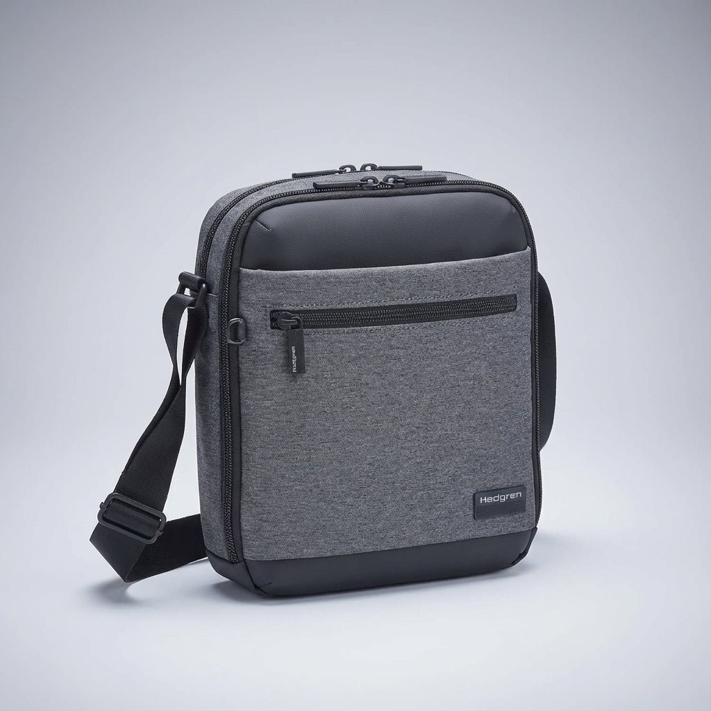 Person bär en svart unisex messengerväska (crossbody) som en praktisk vardags- eller resväska.