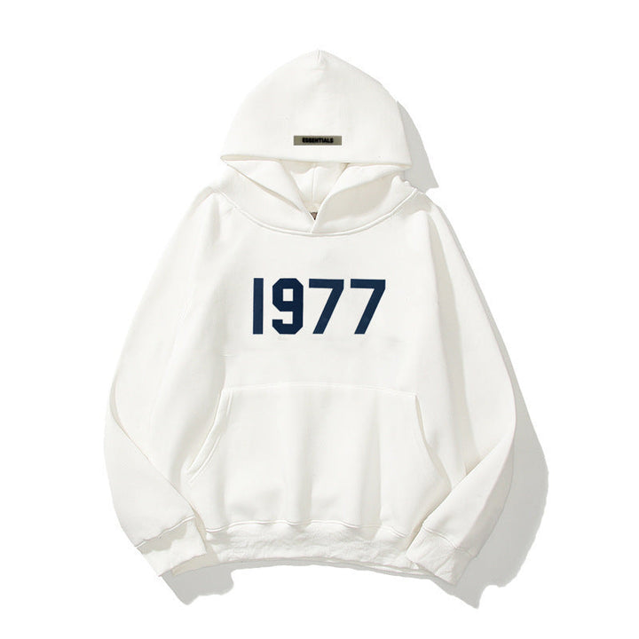 Moderiktig dam- och herrhoodie med raglanärmar, mjukt tyg och coolt 1977-tryck. Stilren och bekväm.