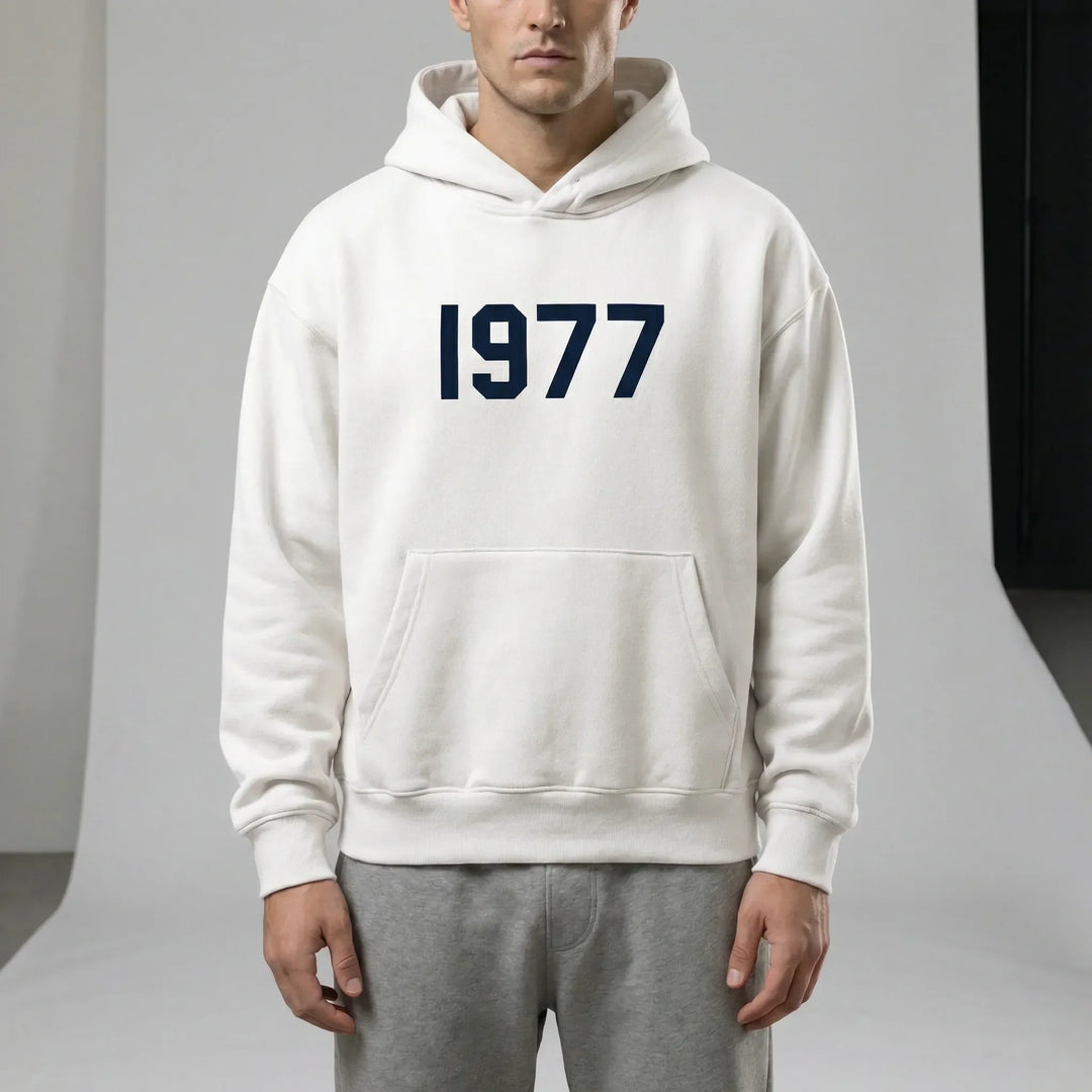 Enfärgad unisex hoodie med kontrasterande raglanärmar och snyggt 1977-tryck.