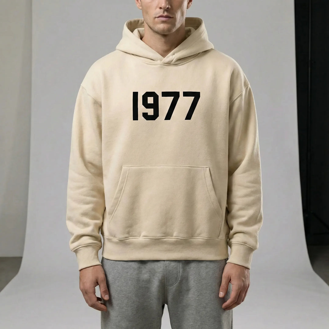 Svart unisex hoodie med vita raglanärmar och stort 1977-tryck framtill.
