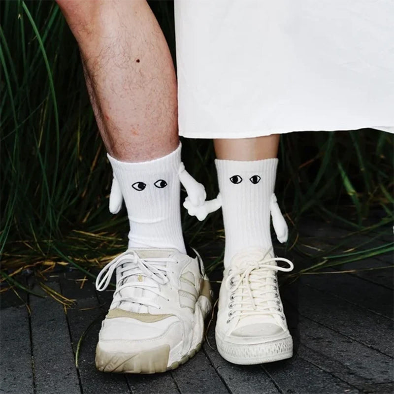 "Unisex strumpor i polyester med magnetiska händer i svart eller vitt, symboliserar kärlek och samhörighet, accessoar."