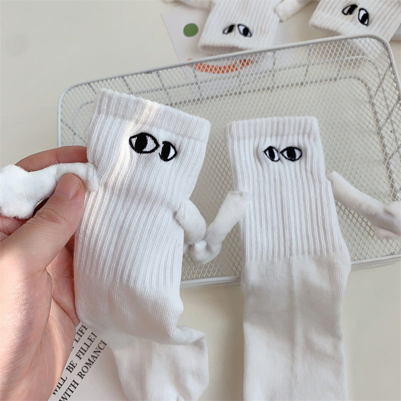 "Unisex strumpor i polyester med magnetiska händer i svart eller vitt, symboliserar kärlek och samhörighet, accessoar."