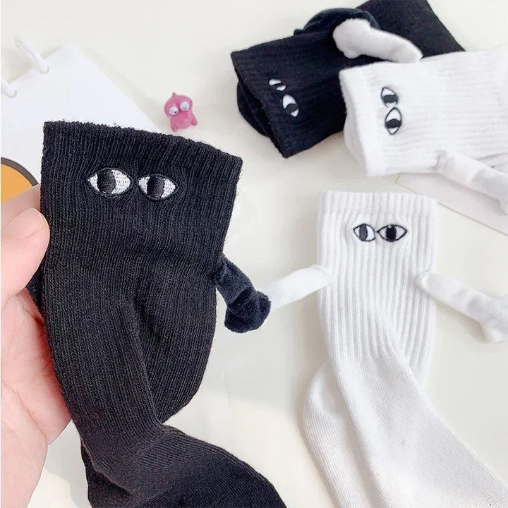 "Unisex strumpor i polyester med magnetiska händer i svart eller vitt, symboliserar kärlek och samhörighet, accessoar."
