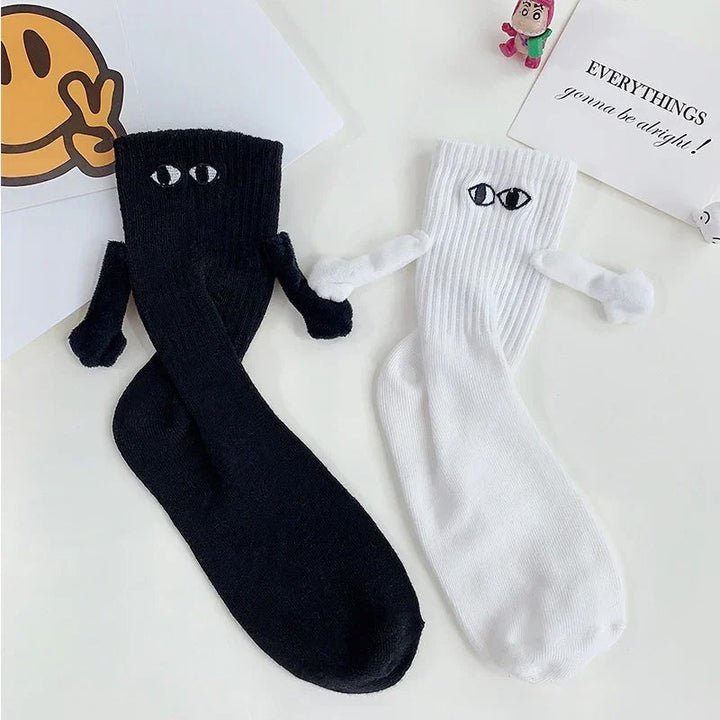 "Unisex strumpor i polyester med magnetiska händer i svart eller vitt, symboliserar kärlek och samhörighet, accessoar."