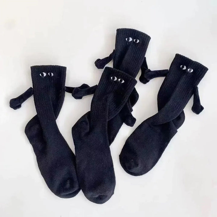 "Unisex strumpor i polyester med magnetiska händer i svart eller vitt, symboliserar kärlek och samhörighet, accessoar."