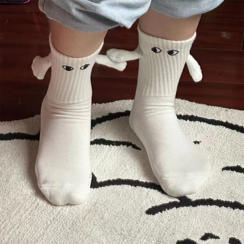 "Unisex strumpor i polyester med magnetiska händer i svart eller vitt, symboliserar kärlek och samhörighet, accessoar."