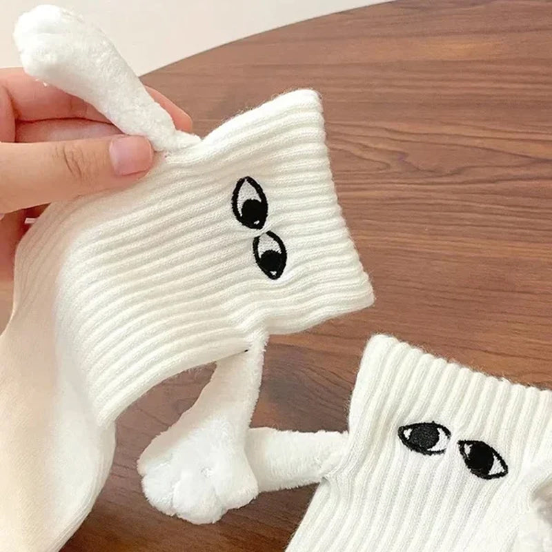 "Unisex strumpor i polyester med magnetiska händer i svart eller vitt, symboliserar kärlek och samhörighet, accessoar."